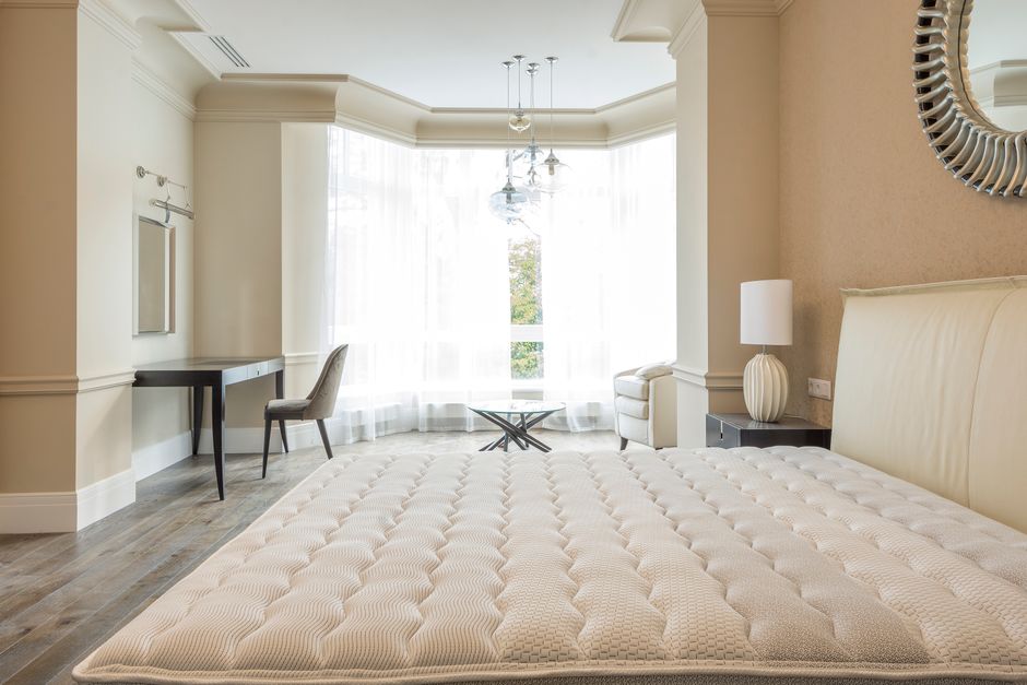 Elegant spacious bedroom with modern furniture, featuring large windows and abundant natural light.